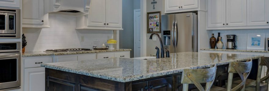 Modern kitchen with stone table and built in appliance.