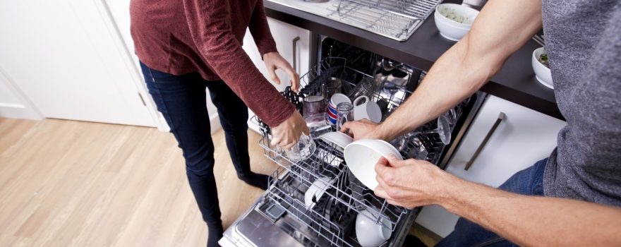 man and woman loading a dishwasher